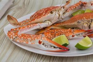 kokt krabbor på de tallrik och trä- bakgrund foto