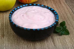 jordgubbe yoghurt i en skål på trä- bakgrund foto