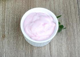 jordgubbe yoghurt i en skål på trä- bakgrund foto