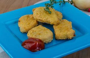 nuggets på de tallrik och trä- bakgrund foto