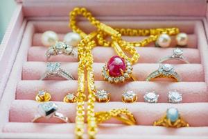 guld och silver- diamant ädelsten safir ringa halsband och pärla örhängen i lyx Smycken låda foto