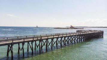 trä- pir förbi de strand och hav i de sommar foto