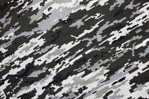 tyg med textur av ukrainska militär pixeled kamouflage. trasa med camo mönster i grå, brun och grön pixel former. officiell enhetlig av ukrainska soldater foto