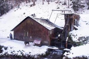 självsäker senior smed i främre av vattenkvarn foto