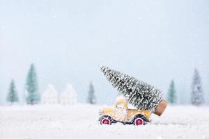 jul träd på leksak bil var löpning genom de snö i de fält av naturlig landskap bakgrund foto