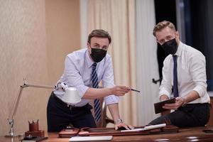 företag människor bär crona virus skydd ansikte mask på möte foto