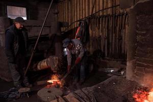 smed arbetare använder sig av mekanisk hammare på verkstad foto