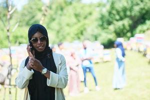 afrikansk kvinna använder sig av smartphone bär traditionell islamic kläder foto