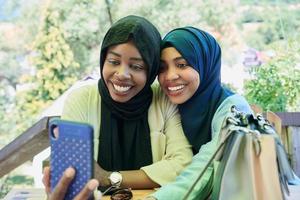 afrikansk kvinna vänner använder sig av smart telefon tillsammans foto