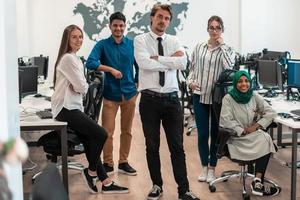 porträtt av ung upphetsad multietniker företag team av programvara utvecklare stående och ser på kamera på modern börja kontor foto