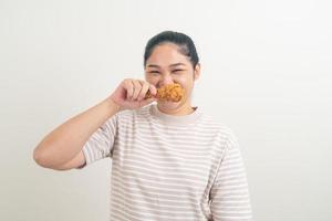 asiatisk kvinna med stekt kyckling till hands foto