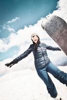 glad upphetsad cool kaukasisk brunett kvinna med himmel poserar i vinter outfit i bergen. kopiera klistra in vertikal bakgrund uppe till vänster foto