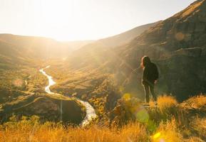 solo- kvinna turist beundra stå på klippig klippa med dramatisk fantastisk caucasian landskap i bakgrund. se från tmogvi fästning i georgien. utforskning av kaukasus sightseeing landmärken foto