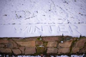 vinter- ord skriven på de snö av de skog foto
