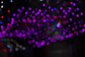lila rosa defokusering abstrakt bokeh ljus effekter på de natt svart bakgrund textur foto