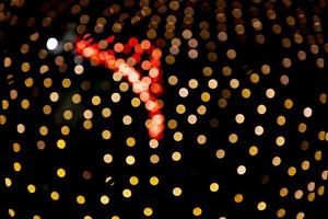gyllene röd dfocus abstrakt bokeh ljus effekter på de natt svart bakgrund textur foto