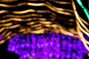 gyllene lila defokusering abstrakt bokeh ljus effekter på de natt svart bakgrund textur foto