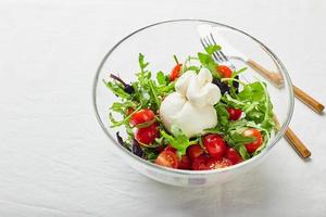 burrata, italiensk färsk ost tillverkad från grädde och buffel eller ko mjölk, med tomat, arugula och röd basilika sallad foto