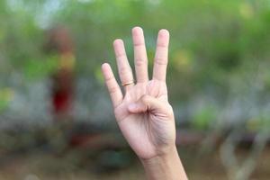 som visar tal använder sig av tecken språk med kvinna händer i isolerat bakgrund foto