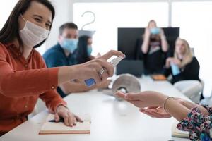 ny vanligt affärsmän på möte använder sig av antibakteriell hand desinfektionsmedel foto