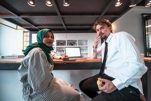 internationell mångkulturell företag team.a ung företag man och kvinna sitta i en modern avslappning Plats och prata handla om en ny företag. foto
