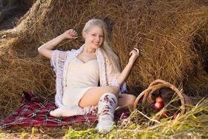vacker blond le kvinna med äpplen i korgen på gården