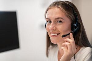 hjälplinje kvinna operatör med hörlurar i ring upp center.business kvinna med headsets arbetssätt i en ring upp Centrum. selektiv fokus foto