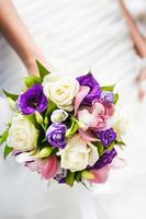bröllop bukett med olika blommor i händerna på bruden foto