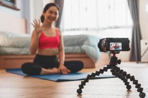 kamera tar video av asiatisk kvinna som utövar yoga foto