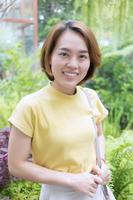 asiatisk kvinna med gyllene kort hår bär en kort ärm t-shirt gul Färg foto