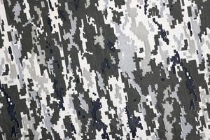 tyg med textur av ukrainska militär pixeled kamouflage. trasa med camo mönster i grå, brun och grön pixel former. officiell enhetlig av ukrainska soldater foto