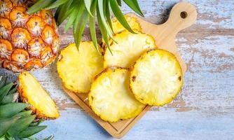 topp se av skivad och halv ananas och färsk ananas frukt placerad på ett gammal trä- bakgrund foto