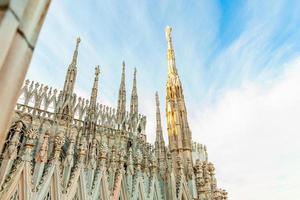 taket på katedralen i milano duomo di milano med gotiska spiror och statyer i vit marmor. topp turistattraktion på piazza i Milano, Lombardiet, Italien. vidvinkelvy av gammal gotisk arkitektur och konst. foto