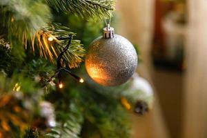 klassiskt juldekorerat nyårsträd. julgran med vit och silver dekorationer, prydnadssaker leksak och boll. modern inredningslägenhet i klassisk stil. julafton hemma. foto