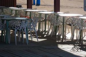 vit metall tabeller och stolar för utomhus- och trädgård använda sig av foto