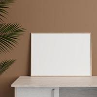 minimalistisk främre se horisontell trä- Foto eller affisch ram attrapp lutande mot vägg på tabell med växt. 3d tolkning.