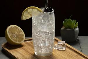 tom collins cocktail i en svart bakgrund, miljövänlig metall sugrör foto