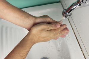 person sanitizing händer foto