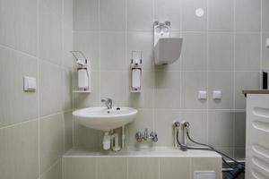 vattenkran av metall med handfat och kran för att sätta på och reglera kallt eller varmt vatten i dyra badrum. foto