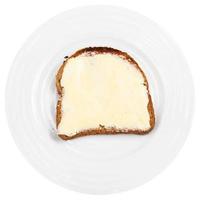 spannmål bröd och Smör smörgås på vit tallrik foto