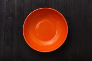 topp se av orange skål på mörk brun tabell foto