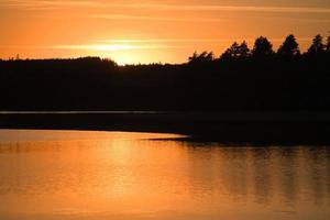 solnedgång med reflexion på en svenska sjö i smalland. romantisk kväll humör foto