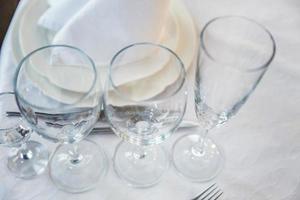 fint bord dukat för middag med servettglas i restaurangen, lyxig inredningsbakgrund. bröllop elegant bankett dekoration och föremål för mat arrangerade av catering på vit duk bord. foto