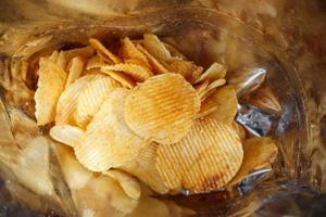 potatischips i öppen snackspåse närbild foto