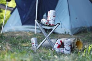 sumy, ukraina - augusti 01, 2021 få burkar av budweiser lageröl alkohol öl på fiskare stol utomhus. budweiser är en varumärke från anheuser-busch inbev foto