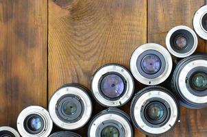 flera fotografisk linser lögn på en brun trä- bakgrund. Plats för text foto