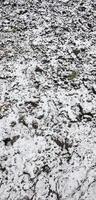 de textur av de jord, täckt med en tunn lager av snö. de jord av de trädgård i vinter. de grävde jord stänga upp foto