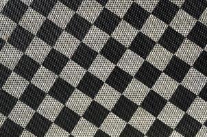 plast textur i de form av en mycket små trasa bindande, målad i svart och grå i de stil av en schackbräde. makro skott foto