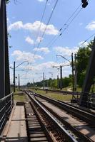 sommar dag järnväg landskap med en se från de järnväg bro till de förorts passagerare station foto