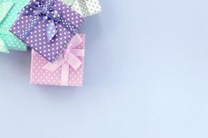 lugg av en små färgad gåva lådor med band lögner på en violett bakgrund foto